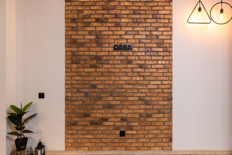 Wall with decorative red bricks insert and pendant design lamps and green plant